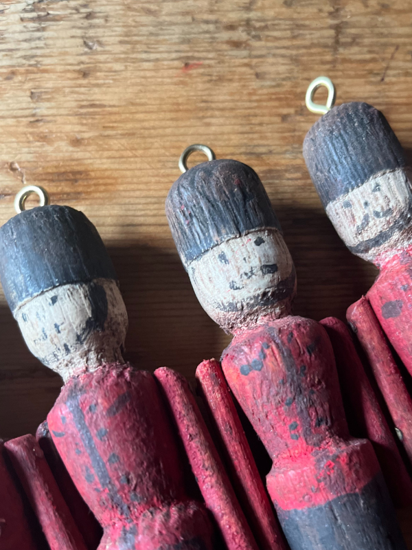 Close up of vintage wooden toy soldiers. Hand painted with red & black uniforms & smiling faces