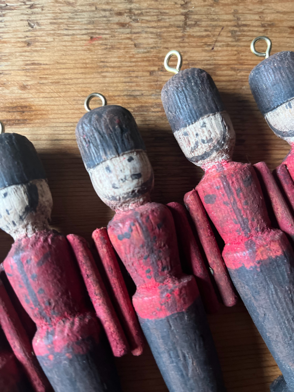 Close up of vintage wooden toy soldiers. Hand painted with red & black uniforms & smiling faces