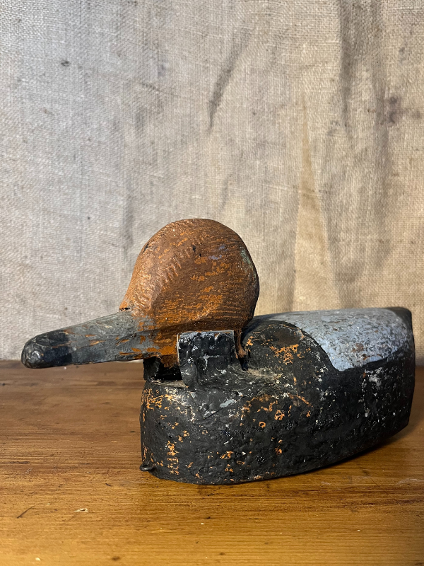 Close up of an antique wooden decoy duck against hessian background