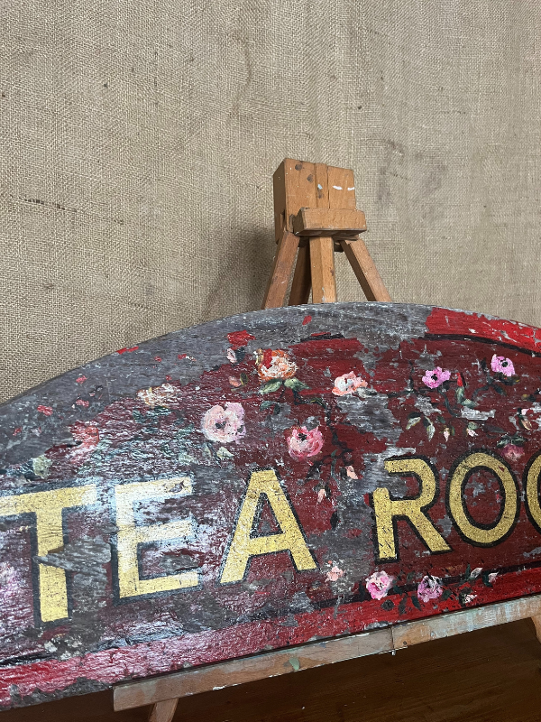 Left hand view of antique Tea Room sign gold letters on red painted background with pink roses