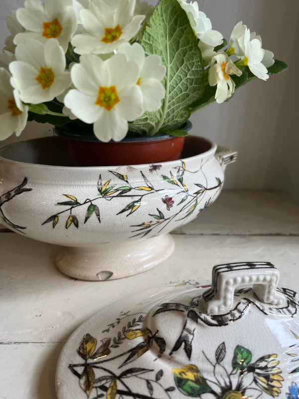 Close shot of a painted floral dish & lid showing chips to the dish