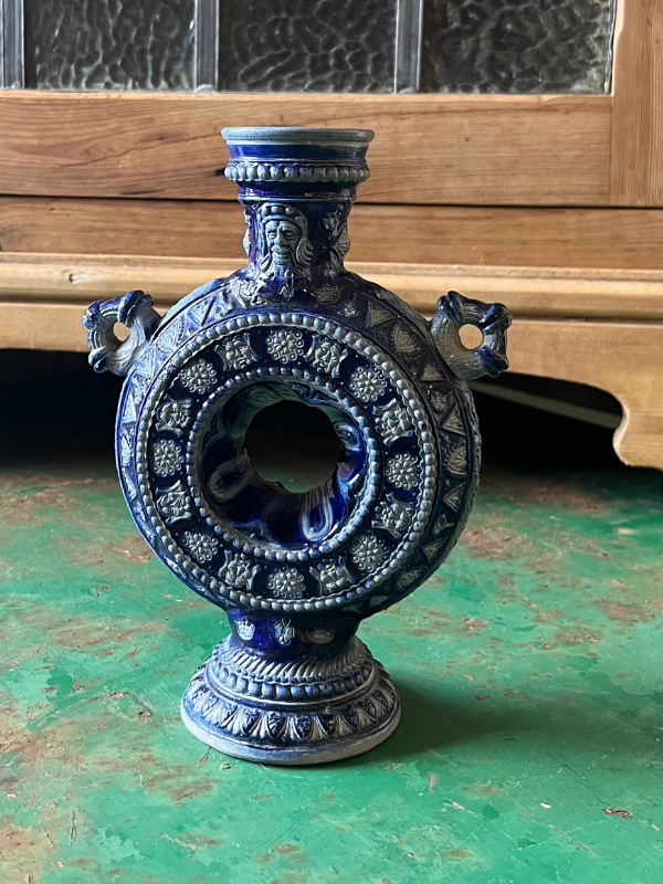 Close view of a blue & white tulipiere vase on a green metal table