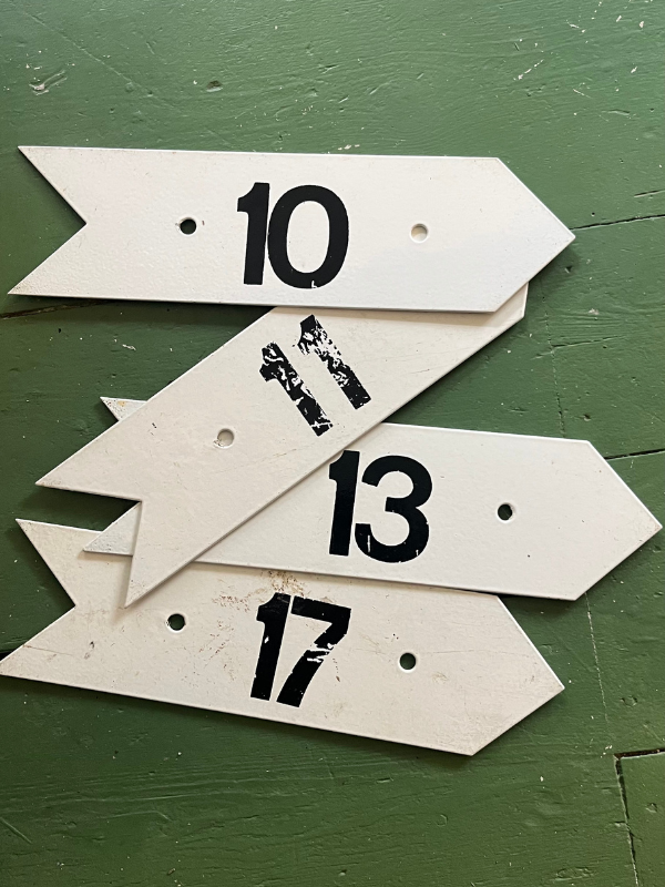 Vintage golf numbers 10 11 13 17 on a green wooden floor