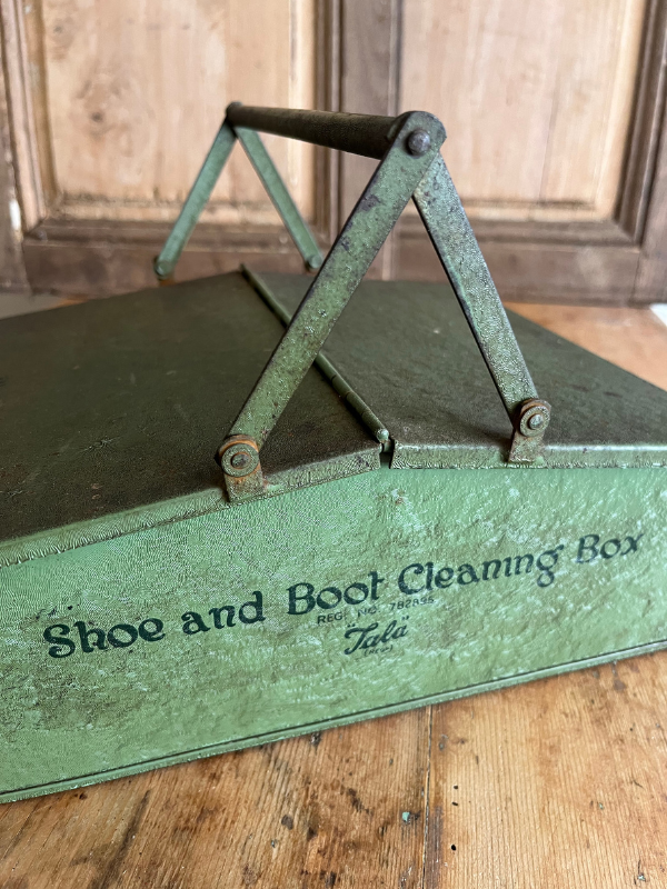 Close up shot of Tala green metal shoe cleaning box on a wooden table