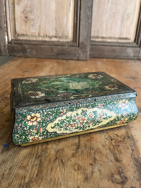 Highly decorated vintage tin on a wooden table
