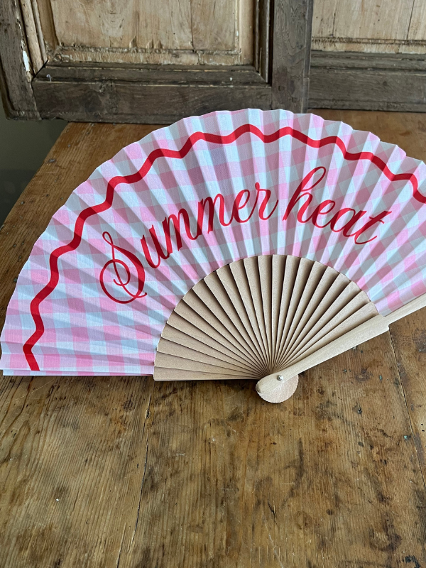 Summer Heat pink gingham fan on wooden table