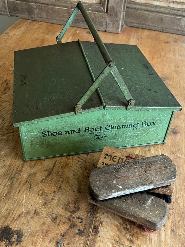 Tala green metal shoe cleaning box with wooden brushes on a wooden table
