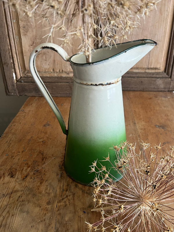 Top view of a two tone green & white enamel jug with dried allium seed heads