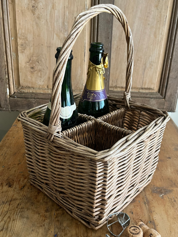 Vintage wicker bottle basket with bottles & corks in the foreground