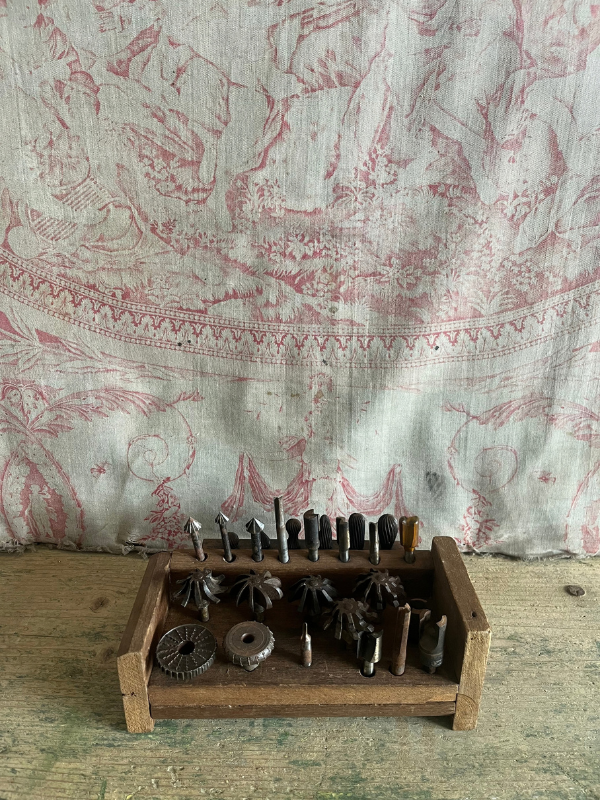 Vintage-decorative-tool-set-against-pink-toile-de-jouy-fabric