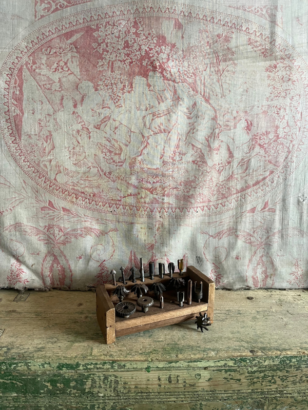 Vintage-tool-set-against-pink-toile-de-jouy-fabric