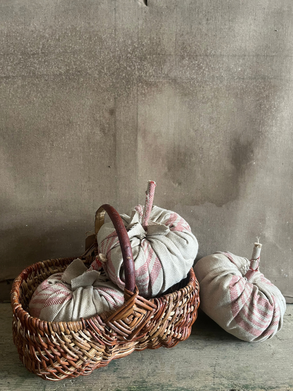 Group-of-handmade-pumpkins-in-beige-ticking-fabric-in-a-wicker-basket