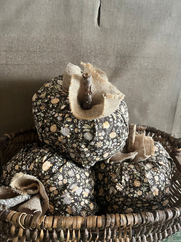 Large brown floral fabric pumkins in a wicker basket