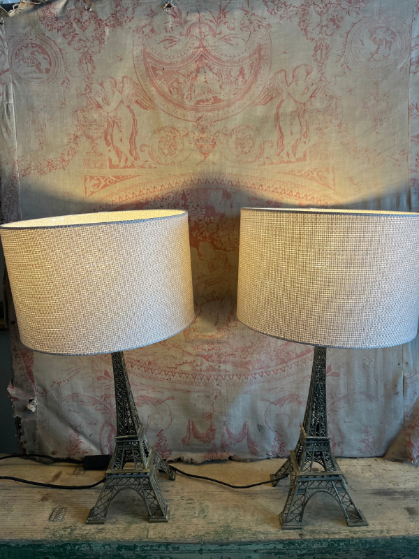 Pair of Eiffel Tower lamps against pink toile de jouy fabric