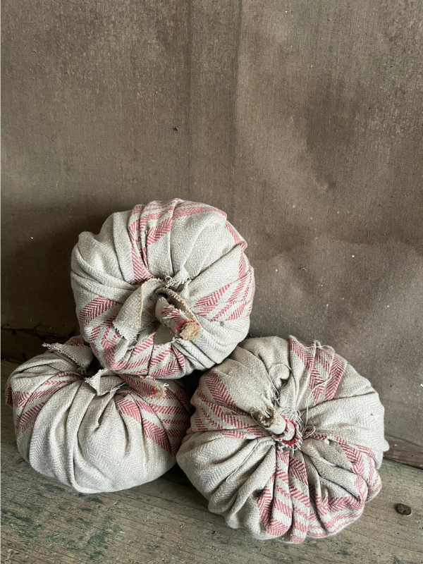 Top view of a group of handmade pumpkins in beige ticking fabric